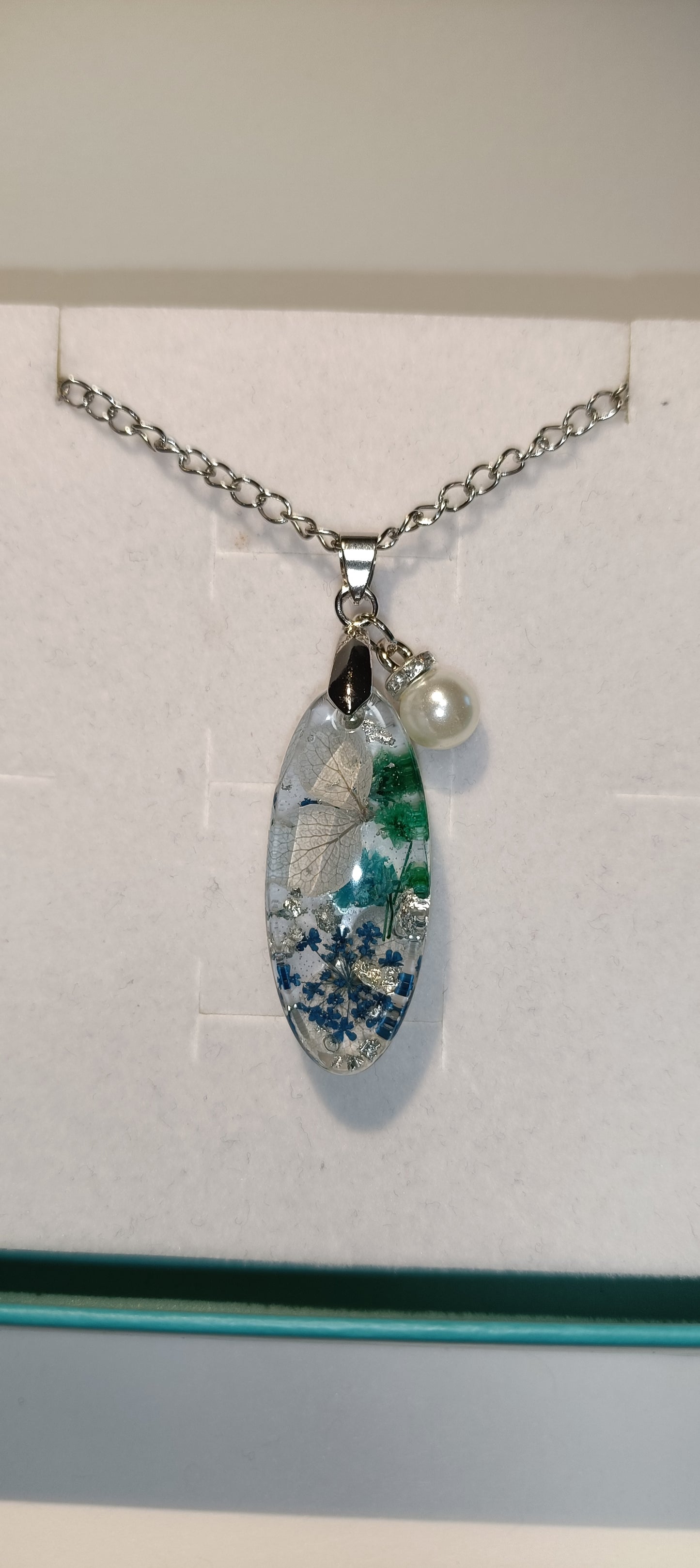 Collana con pendente ovale lungo, con una perla e con fiori veri, carta color argento
